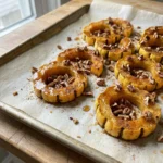 A top-down view of maple roasted delicata squash on a white serving plate.