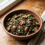 A spoonful of mushroom wild rice pilaf showing the texture of the grains.