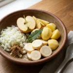 A spoonful of smooth parsnip soup being lifted from a rustic bowl.